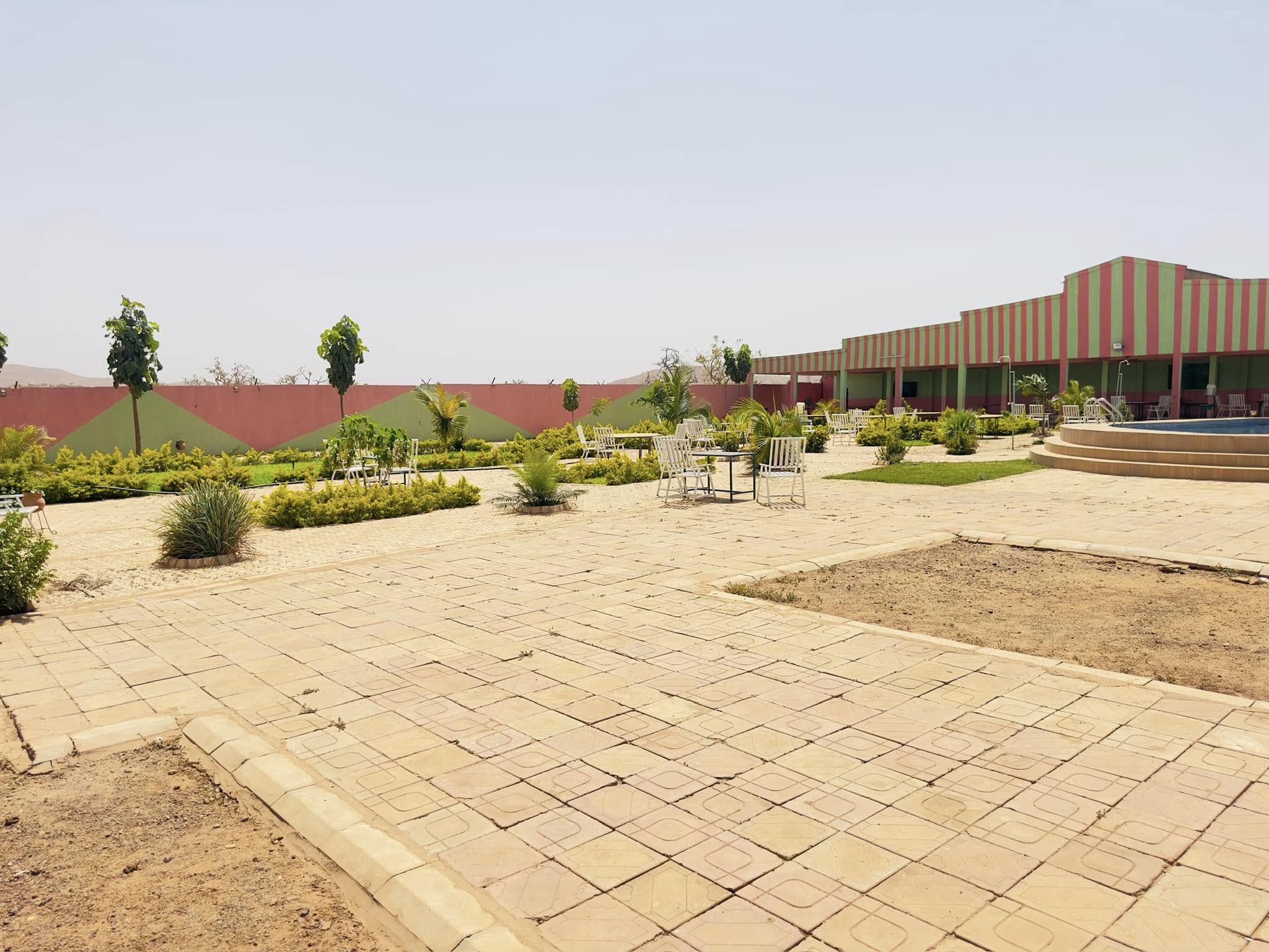 Jardin du site de l'EPCO avec tables et chaises blanches
